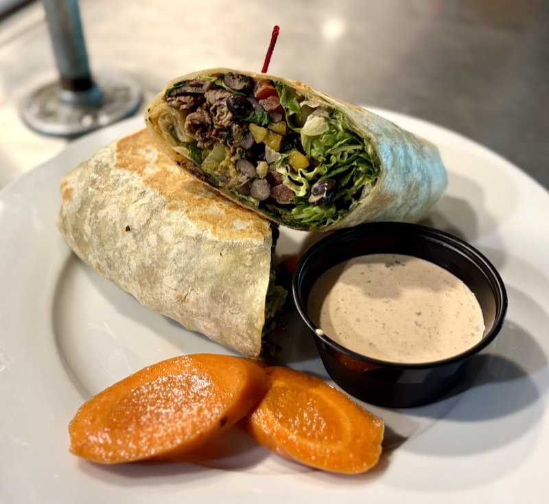 Burrito cut open showing steak, black beans, and fresh vegetables