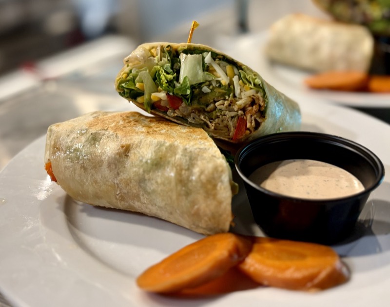 Chicken wrap cut in half with lettuce, corn, and cheese