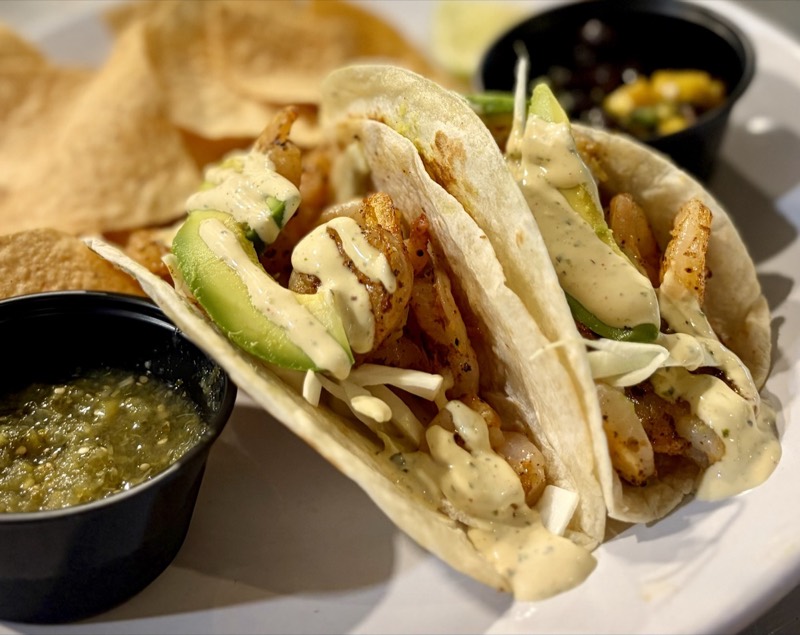 Shrimp tacos with avocado, cabbage slaw, and cilantro crema