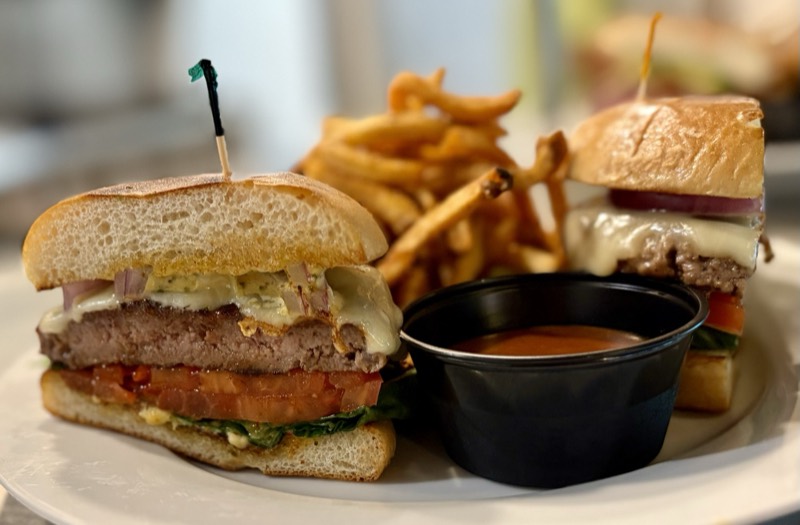 Smash burger with melted cheese, tomato, and red onion, served with fries