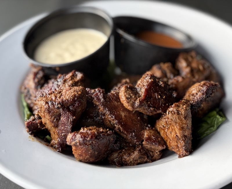 Grilled steak bites served with two dipping sauces