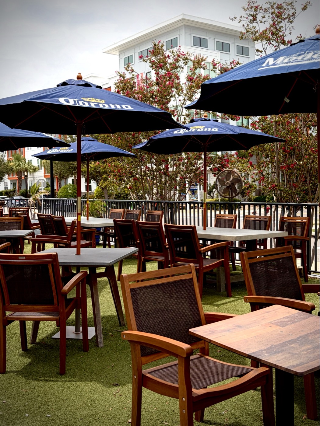 The City Dog Cantina patio with Corona umbrellas, turf, and shaded tables